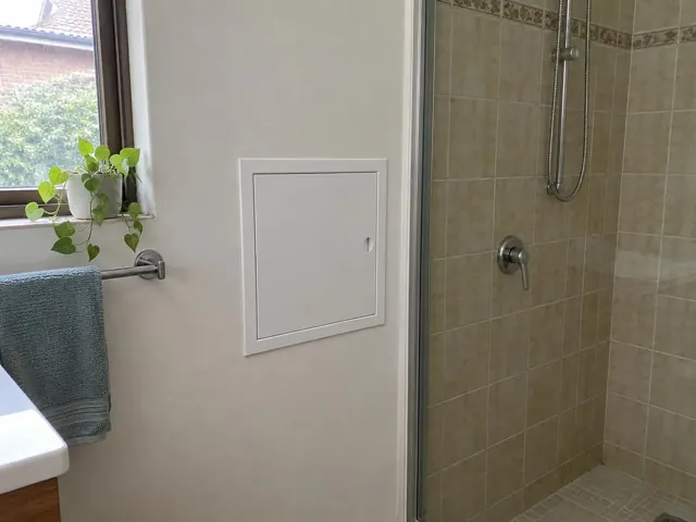 Neat access panel on a bathroom wall beside a tiled shower in Seaforth